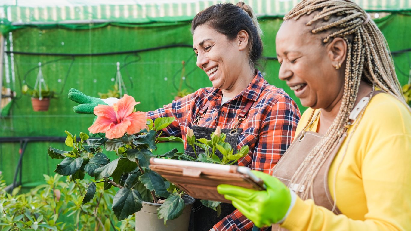two women working together in container gardening inside their community